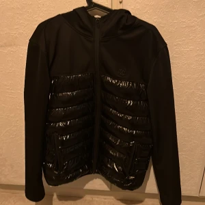 Cardigan svart - Cardigan med svart glans. Väldigt snyggt och knappt använd. Köpte den på Plick helt ny men säljer nu vidare. Skick 9/10. 