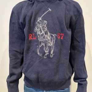 Polo raulph lauren hoodie - Det här är en väldigt fin och snygg stickad raulph lauren hoodie som är väldigt skön och fin. Modellen är 167 och väger runt 50kg. Nypris på denna tröja var runt 2600kr och mitt pris är 1000kr. De har slutat tillverka denna tröja så köp när du kan!!😀