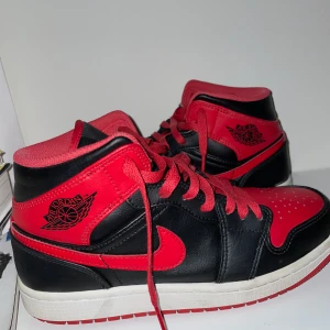 Jordan 1 mid bred - Ett par otroligt snygga Jordan 1 som är trendiga och passar till vilken årstid som helst. Säljer för att jag har växt ur dem tyvärr. De har ett väldigt bra skick. Hör av er vid funderingar. Står som vanligt inte för postens slarv. Box tillkommer.