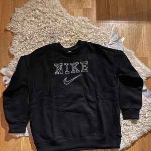 Nike Vintage Sweatshirt  - Introducing a classic black retro Nike sweatshirt in excellent 9/10 condition. This timeless piece effortlessly blends comfort and style, showcasing the iconic Nike design. Perfect for a casual yet trendy look.
