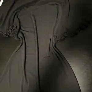Snygg kort klänning med transparent tyg över axlarna.