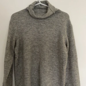 Stickad tröja - Grå stickad polotröja i storlek S från lager 157. Känns liten i storleken då den har korta ärmar. Litet hål på ryggen under kragen, men annars i gott skick!