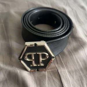 Phillip plein  bälte  - En ganska helt ny Phillip plein, äkta men ingen kvitto tyvärr därför säljer jag den för 2000 kr, ny pris 5520 kr och den är  storlek 110