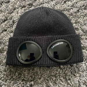 C.P. Company Mössa - En relativt ny svart mössa från cp company. Mössan är nästan oanvänd och en av dess tags finns kvar. Kom pm för frågor eller fler bilder 👌