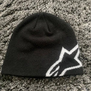 Alpinestars mössa - En skön mössa av märket alpine stars som är svart med ett vitt motiv (deras logga)  Mössan är i fint skick och har använts försiktigt, alltså inga hål eller defekter. Skriv pm för frågor eller fler bilder 👌
