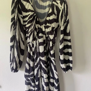 Zebraklänning från HM - Jättecool klänning i zebramönster från HM. Köpt i Italien förra året. Använd 2-3 gånger endast. Strl XS men skulle säga att den passar ändå upp till M då den är stretchig. 