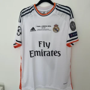 Real Madrid 2013/14 UCL final - Ronaldo  - Skick: helt nytt och oanvänd  Storlek: M Tröjan finns i Stockholm/Vallentuna men frakt erbjuds via postnord (2-3 dagar)  Skriv till mig ifall ni har en fråga.