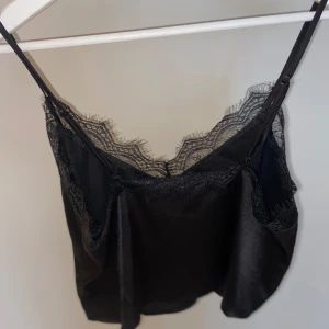 Satin linne - Ett linne i satin liknande material (polyester och elastan)  Storlek 36  Finner inget att anmärka då den är oanvänd 