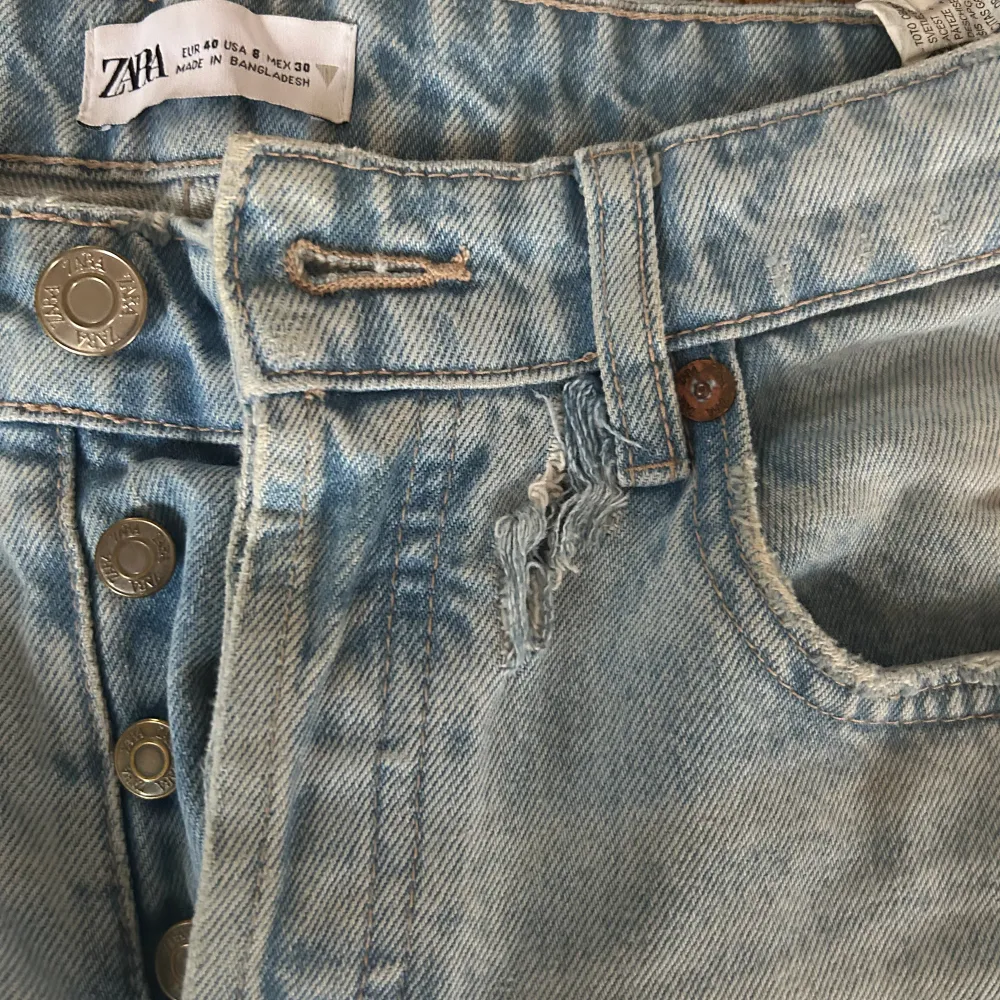 Jeansen ljusblå från Zara och är raka i benen och har medelhög midja. Storleken är 40 och tyvärr har jeansen ett litet hål men annars är de i bra skick. . Jeans & Byxor.