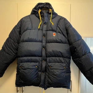 Fjällrävenjacka - Köpt i andrahand för 3500kr för några månader sedan. Skön, fluffig jacka som är väldigt varm, äldre modell. Jackan har inga hål eller skador, enda att påpeka är att ”spännena” är lite nötta, se sista bilden.  Säljes pga att jag vill köpa i annan färg