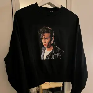 En svart sweatshirt med tryck av Johnny Depp i filmen ”Cry baby”, vilket även är motivet som står på baksidan av tröjan!💓🙏🏻