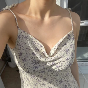 Söt sommarklänning  - Luftig, söt och kort sommarklänning med justerbara axelband. Klänningen är beige med små fina lila blommor. 🪻🤍💜 Klänningen har inga tecken på användning. Märket är Nakd och klänningen är i storlek 36 men stor i passformen. (Nypris: 299kr)