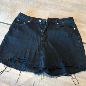 Jeans-shorts  - Svarta, slitna ( ska vara så ) jeans shorts i fint skick. Fickor på sidorna fram och fickor bak.  Djur finns i hemmet