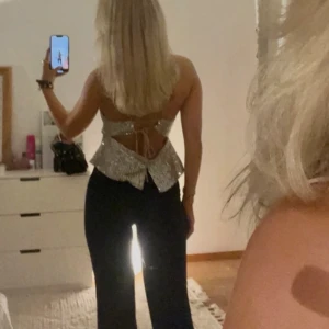 Topp - Jättefin glittrig topp i en grå/beigeglittrig färg med öppning i ryggen. Endast använd 1 gång💕💕