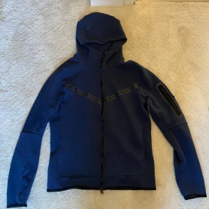 Nike Tech Fleece dress - Nike tech dress i bra skick. Den är använd ett par gånger. Storlek S i både byxa och huvtröja.