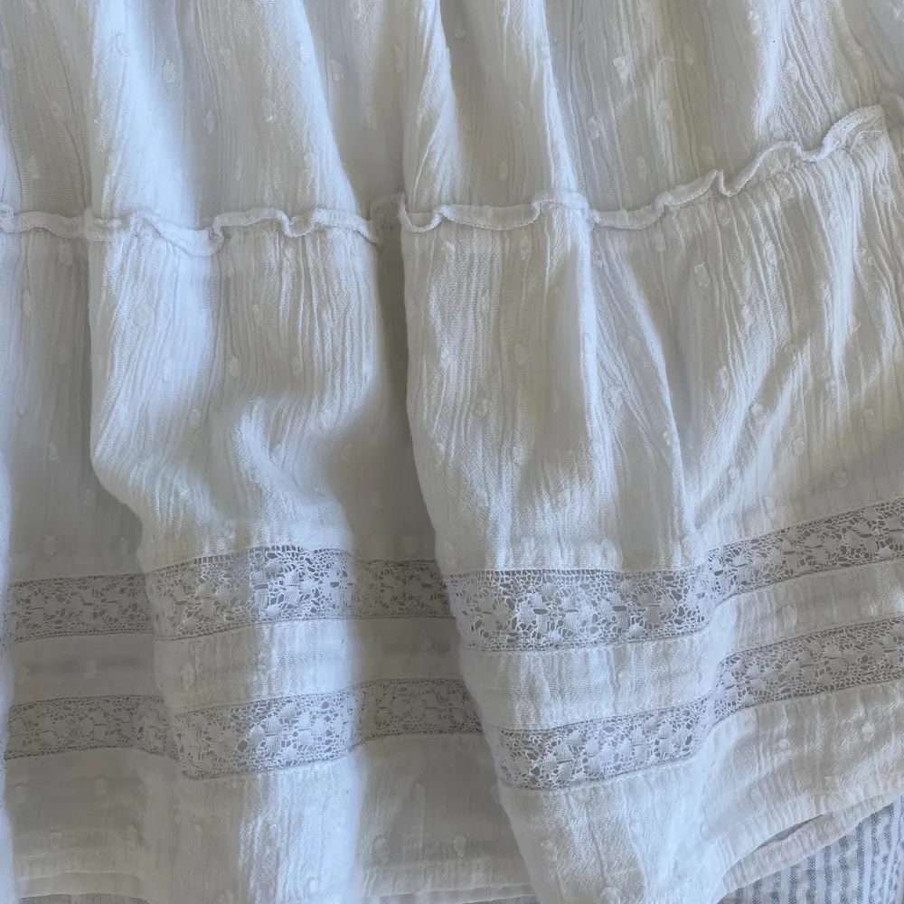 Superfin vit kort kjol från Hollister med broderidetaljer. Underkjol finns så den är inte genomskinlig! Liten antydan till missfärgning högst upp av solkräm💗. Kjolar.
