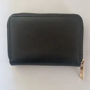 En svart plånbok med bra utrymme for kort och kontanter. (pris kan diskuteras men du hämtar själv i hovsaga Växjö)