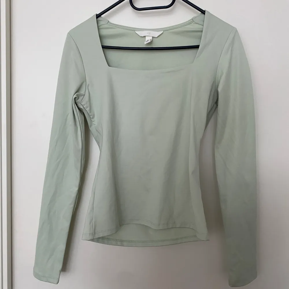 En grön tröja från hm i storlek S med fyrkantig urringning. Aldrig använd. Blusar.