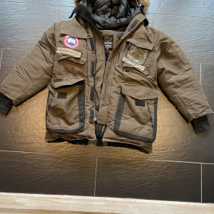 Canada Goose vinter jacka - Perfekt till dig som vill hålla dig ruggigt varm inför kommande vinter. Skicket är bra och den är i färgen olivgrön.