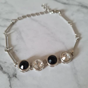 Armband svart vit - Fint armband. Okänt märke & material. Mycket fint skick. Själva knäppet går inte att öppna helt men funkar bra att ta på och av ändå.