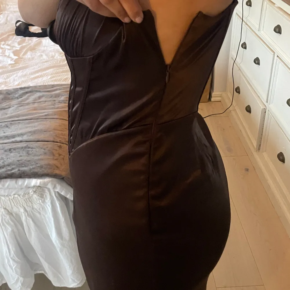 Mörkbrun sexig balklänning från NAKD. I helt nytt skick, aldrig använd, lappen av köpet är kvar. Storlek 42. Lite stor, men största anledningen för försäljning är att jag inte kommer använda den. Vid intresse kan priset diskuteras. . Klänningar.