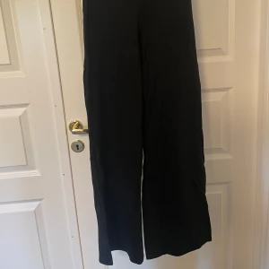 Svarta byxor  - Svarta byxor från Gina Tricot, rejält utsvängda nertill. Använda men i fint skick
