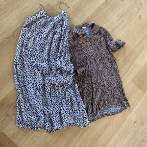 Två leopardmönstrade klänningar - Säljer två snygga leopardmönstrade klänningar. Den ena är en långklänning med smala axelband och den andra är en kortklänning med krage och korta ärmar. Båda klänningarna är perfekta för sommaren och festliga tillfällen. De är i bra skick och redo för nya ägare!