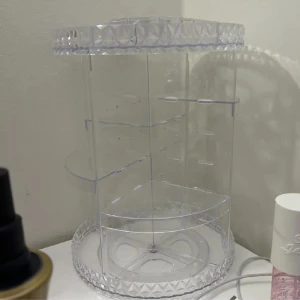 Roterande sminkorganisator i akryl - Säljer en superpraktisk roterande sminkorganisator i genomskinlig akryl. Den har flera fack och hyllor för att hålla ordning på alla dina sminkprodukter. Perfekt för att organisera läppstift, borstar, och andra småsaker. Den är både snygg och funktionell, och passar perfekt på sminkbordet!