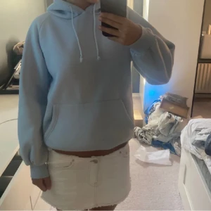 Ljusblå hoodie - Säljer en supermysig ljusblå hoodie. Den är perfekt för kyliga dagar och har en stor ficka på magen samt en justerbar huva med snören. Tröjan är i bra skick och passar perfekt till både jeans och kjol. Perfekt för höst och vinter! 💙