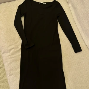 Svart långärmad klänning - Säljer en elegant svart långärmad klänning. Den är perfekt för både vardag och fest. Klänningen är i ett mjukt och bekvämt material som formar sig fint efter kroppen. Den har en enkel och stilren design som gör den lätt att matcha med olika accessoarer. Passar perfekt för höst och vinter!