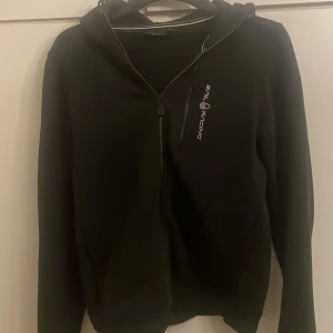 Sail racing huvtröja - Svart zip up hoodie från sail racing, en liten fläck nedtill (se bild) men annars inga skador eller liknande🙏🏽