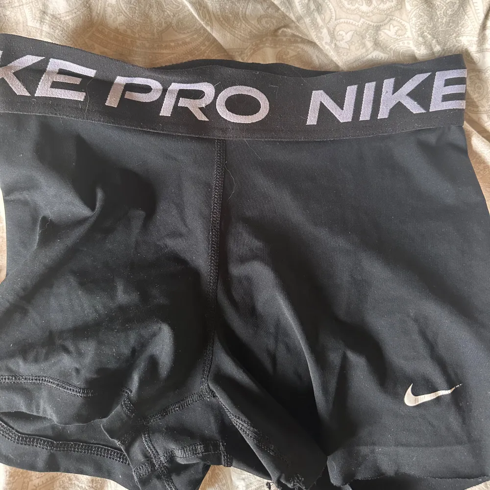 Säljer ett par svarta träningsshorts från Nike Pro. De är använda några gånger och har en tight passform. Shortsen är gjorda av polyester och har en elastisk midja med Nike Pro-loggan. Perfekta för träning eller andra sportaktiviteter.. Shorts.