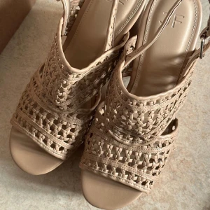 Helt nya klackskor  - Helt nya klackskor •	Skick: Helt nya och oanvända 	•	Material: Läder med spetsdetaljer 	•	Klackhöjd: 10 cm 	•	Storlek: 39 	•	Färg: Beige