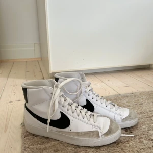 Vita Nike Blazer sneakers - säljer ett par vita höga-Nike Blazer sneakers i storlek 38.5 ❣️❣️skorna är i välanvänt skick. nypris är runt 900 kr. skriv för mer bilder! 