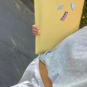 Gul datorväska med klistermärken - Säljer en superfin gul datorväska som är perfekt för att skydda din laptop. Väskan har en dragkedja upptill och kommer med tre coola klistermärken: en med texten 'BOOM', en blixt och ett moln. Perfekt för att ge din väska en personlig touch!