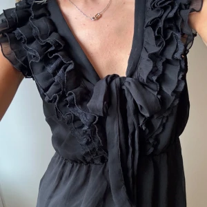 Blus - H&M - Säljer denna svarta blus från H&M då den inte kommer till användning. Den är i ett fint skick. Står ingen storlek i men skulle säga att den är en XS/S.