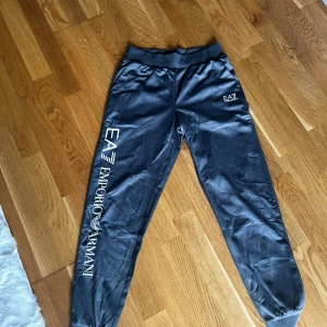Mjukisbyxor Armani  - Gråa mjukisbyxor från emporia Armani. Med tryck längst benen. Liten i storlek.