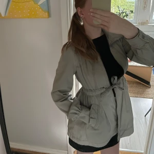 Grå kappa  - Denna vår kappa är en perfekt jacka nu till sen sommaren då det börjar bli lite kyligare ute. Lappen sitter fortfarande kvar då den aldrig blivit använd, alltså är den i mycket bra skick. Tveka inte att ställa era frågor till mig om ni undrar något!😍