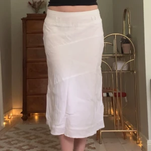 Linnekjol - Midikjol i vitt linnetyg med fina sömdetaljer och hylsor för skärp, vintage Lindex! Jag är 173 cm, midjemåttet är 80 cm och längden 72 cm 🤍