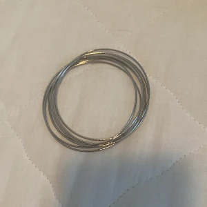 Silverfärgat armband - Ett enkelt och stilrent armband i silverfärg. Armbandet består av flera tunna ringar som är sammanlänkade.