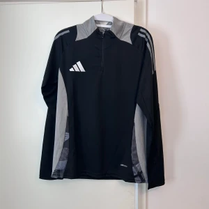 Adidas träningströja - Helt ny och oanvänd Adidas träningströja i färgerna svart och grå. Säljs pga att den inte passar mig. Det är bara att höra av sig om man har frågor.