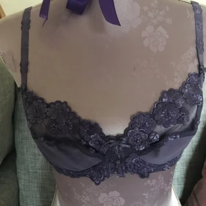 Lila blommig behå - Lila behå, den är sparsamt använd och inga fel på sig. Storlek 75.  Jag tar helst Swish och skickar efter mottagning betalning 