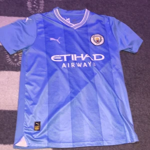 Manchester city tröja 2023 - Det är en tröja som är från city shopen. Den är helt oanvänd. Och den är äkta. 