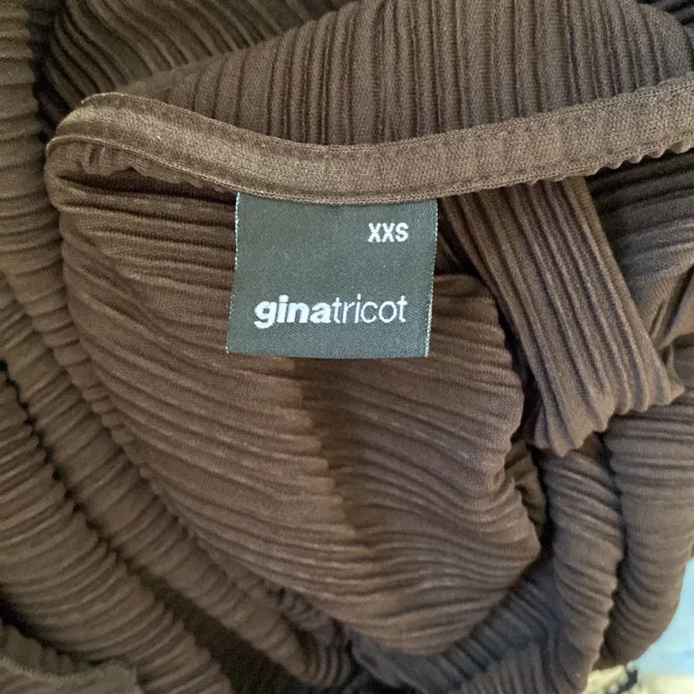 Säljer denna jätte fina bruna blus från Gina tricot. Den har detaljer i båda armarna och är i ett veckat material. Tröjan är i väldigt bra skick och är storlek xxs men känns som en xs eller s🩷. Blusar.