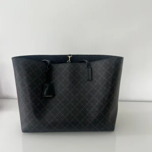 Malena Birger väska  - Säljer denna by Marlene Birger väskan, då den inte längre kommer till användning. Den är svart med brun.  Väskan kostar 3000 kr ny  Mitt pris 1500 kr  Fler blir kan fås.