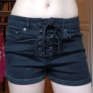 Svarta jeansshorts med band - Skit snygga svarta jeansshorts med fina band och justerbar midja. Köpta från new yorker. Passar väldigt bra nu till sommaren💕 Skriv till mig för mer information💛
