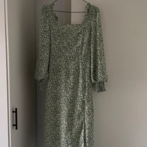 Midsommar Klänning - Med slits på benet och resår i ryggen och armarna. Tror att den är felsydd framtill, så har sytt några stygn där som lätt går att lösa upp. Sparsamt använd. 