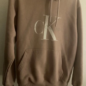 Calvin Klein - Gråaktig Rosa CK hoddie, använd några gånger. Skön hoddie till sommaren, köpt för 850kr pris kan diskuteras 