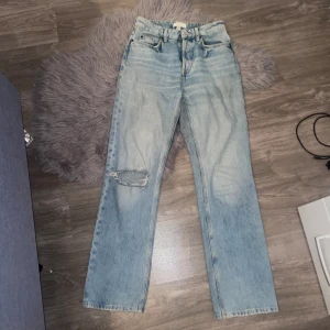 jeans - Jeans ljusblå med hål i ena knät, högmidjade med knappar (se bild 2)   Kontakta för mer info/fler bilder. Kan postas men köpare står för frakten, kan mötas upp i malmö. 