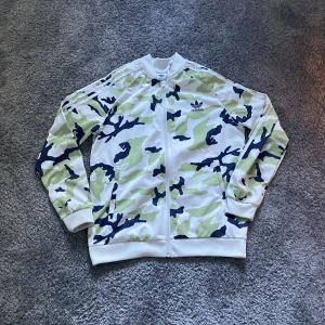Vit Adidas zip - Tjena! Säljer denna riktigt snygga Adidas zip eftersom den har blivit för liten. Jag har bara använt den ett fåtal gånger, 9/10 skick. Om ni har några frågor eller funderingar är det bara att skriva!